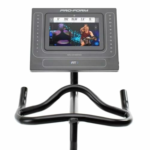 Exercise bike console with screen displaying a workout video