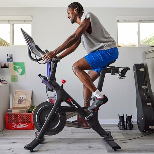 Man exercising on a Peloton bike indoors.