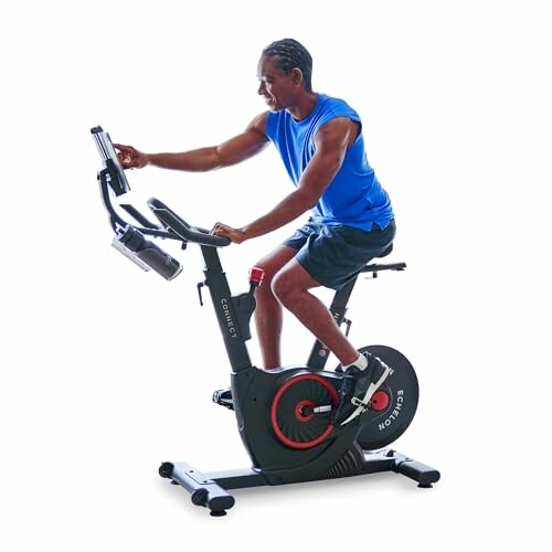 Man using an exercise bike with a tablet holder.